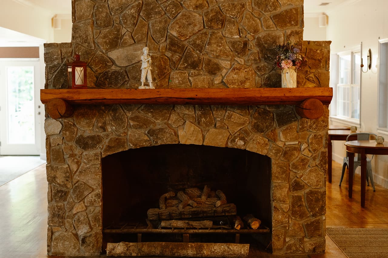 The stone fireplace and wooden mantel in the great room