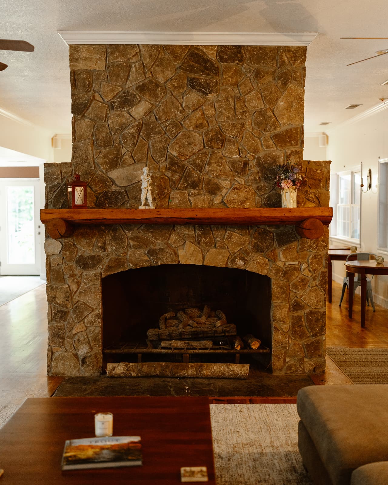 A floor-to-ceiling stone fireplace in the great room, the dining room beyond