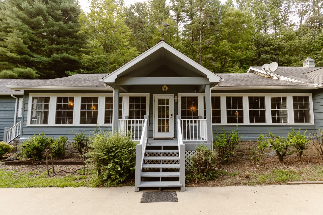 The main building at Blue Boar Inn, steps up to a porch and a long run of windows